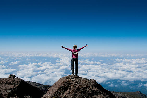 A happy trekker above the clouds on the route to the summit of Kilimanjaro